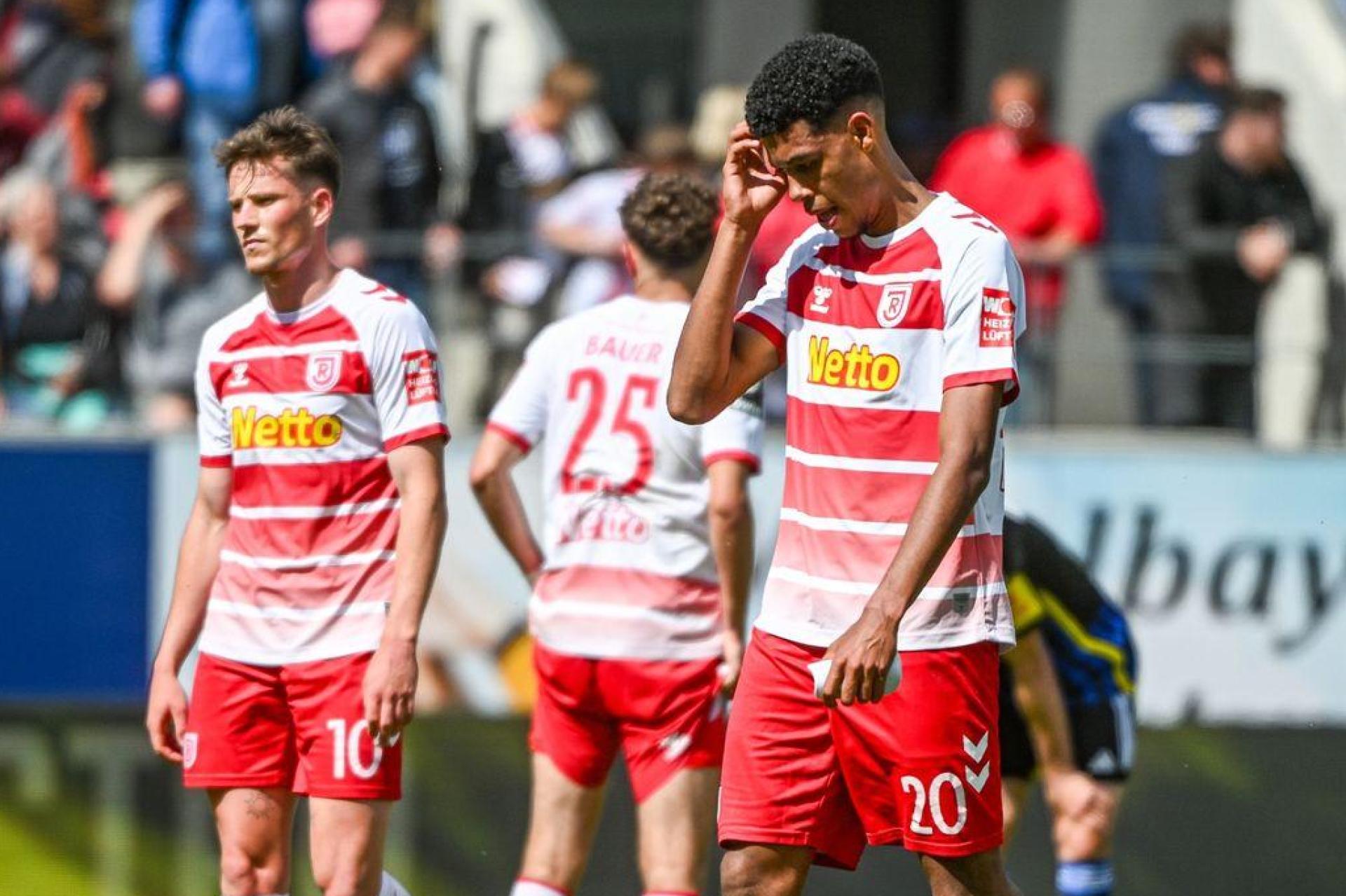 Die Mannschaft von Regenburg steht nach dem mit 0:1 verlorenen Spiel gegen Saarbrücken auf dem Rasen. (Bild: Armin Weigel/dpa)