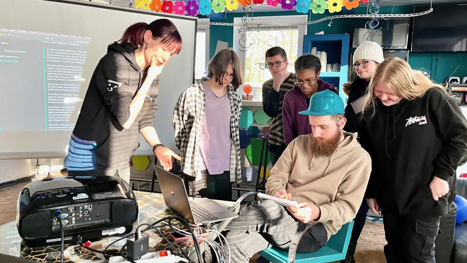 Pädagogin Denise Schatzkowski (links) und Spieleentwickler Laurin Muth (sitzend) arbeiten einmal wöchentlich mit einer Gruppe Jugendlicher an dem Computerspiel „Digitales Weiden”.  (Bild: Gabi Schönberger)