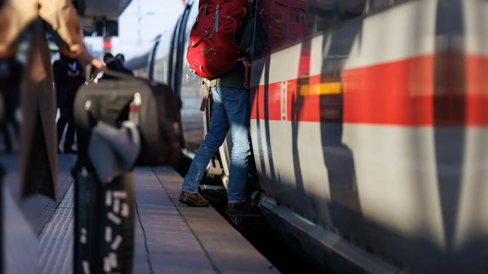 Reisende stehen mit Gepäck am Bahnsteig am Nürnberger Hauptbahnhof an einem ICE. (Bild: Daniel Karmann/dpa)