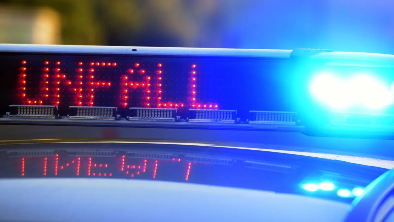 Auf einem Polizeifahrzeug warnt eine Leuchtschrift vor einer Unfallstelle. (Bild: Stefan Puchner/dpa/Archivbild)