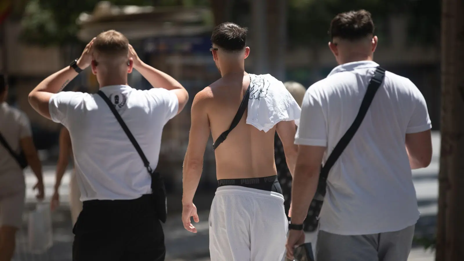 Angesagt bei jungen Männern: das klassische weiße T-Shirt. Aber auch: zeigen, was man hat. Blanke Brust? Tattoos? Waschbrettbauch? (Archivbild) (Bild: Clara Margais/dpa)