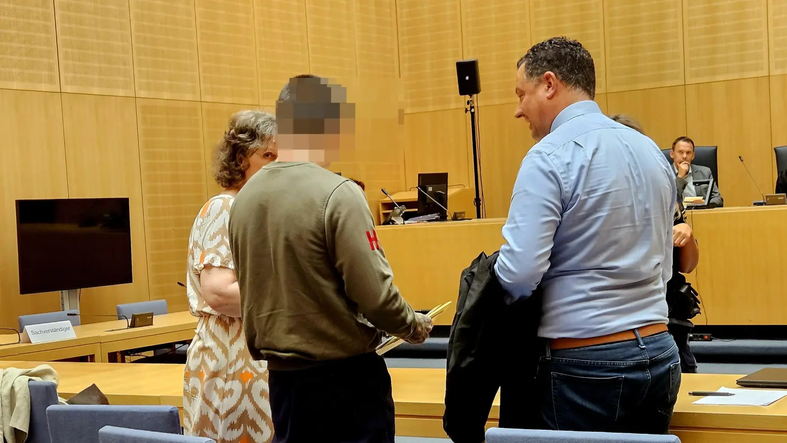 Erikas G. (im dunkelgrünen Pullover) ist wieder ein freier Mann. Nach dem Urteil spricht er mithilfe seiner Dolmetscherin (links) mit Anwalt Maximilian Schewe.  (Bild: blf)