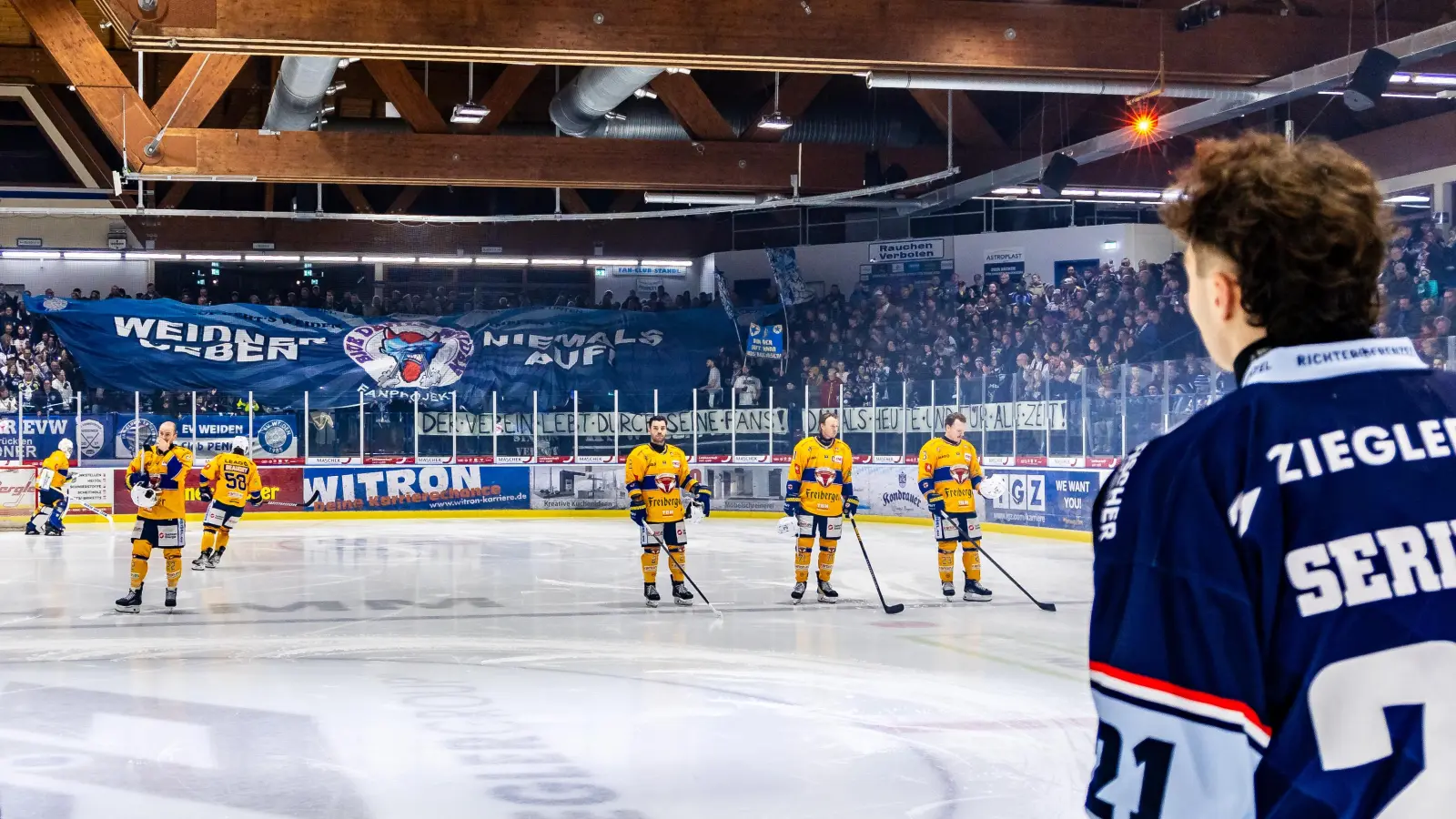 Nach den News zum Insolvenzantrag der Ziegler Holding präsentiert die Fankurve vor dem Heimspiel gegen die Lausitzer Füchse die Blockfahne „Weidner geben niemals auf“ und das Spruchband „Der Verein lebt durch seine Fans! Damals, heute und für alle Zeit“. Die prominente Werbefläche auf dem Rücken der Spielertrikots (im Bild Finn Serikow) wird frei und neu vermarktet. (Bild: Tobias Neubert/exb)