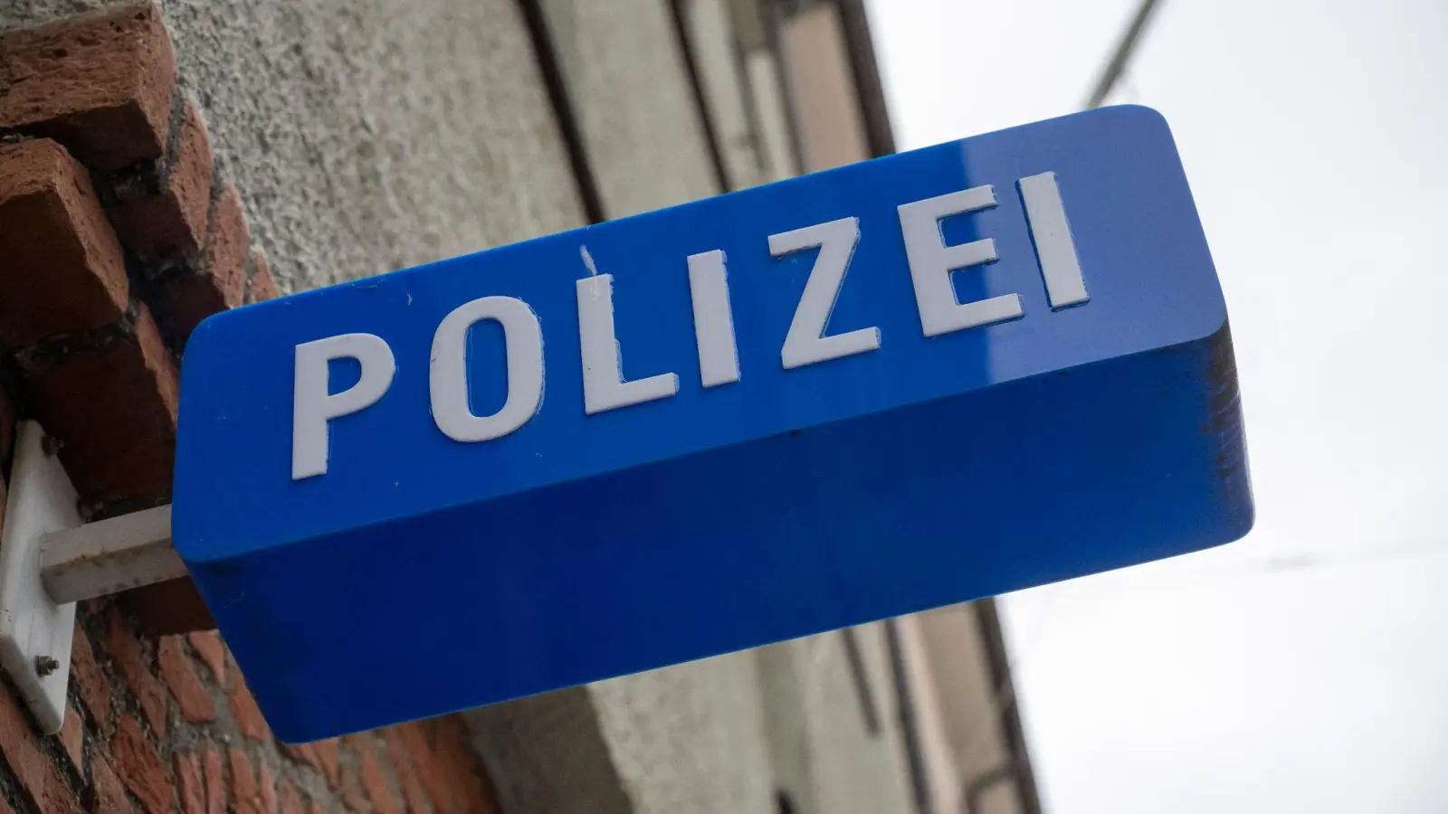 Ein Schild hängt am Eingang zu einer Polizeiinspektion. (Bild: Peter Kneffel/dpa/Symbolbild)