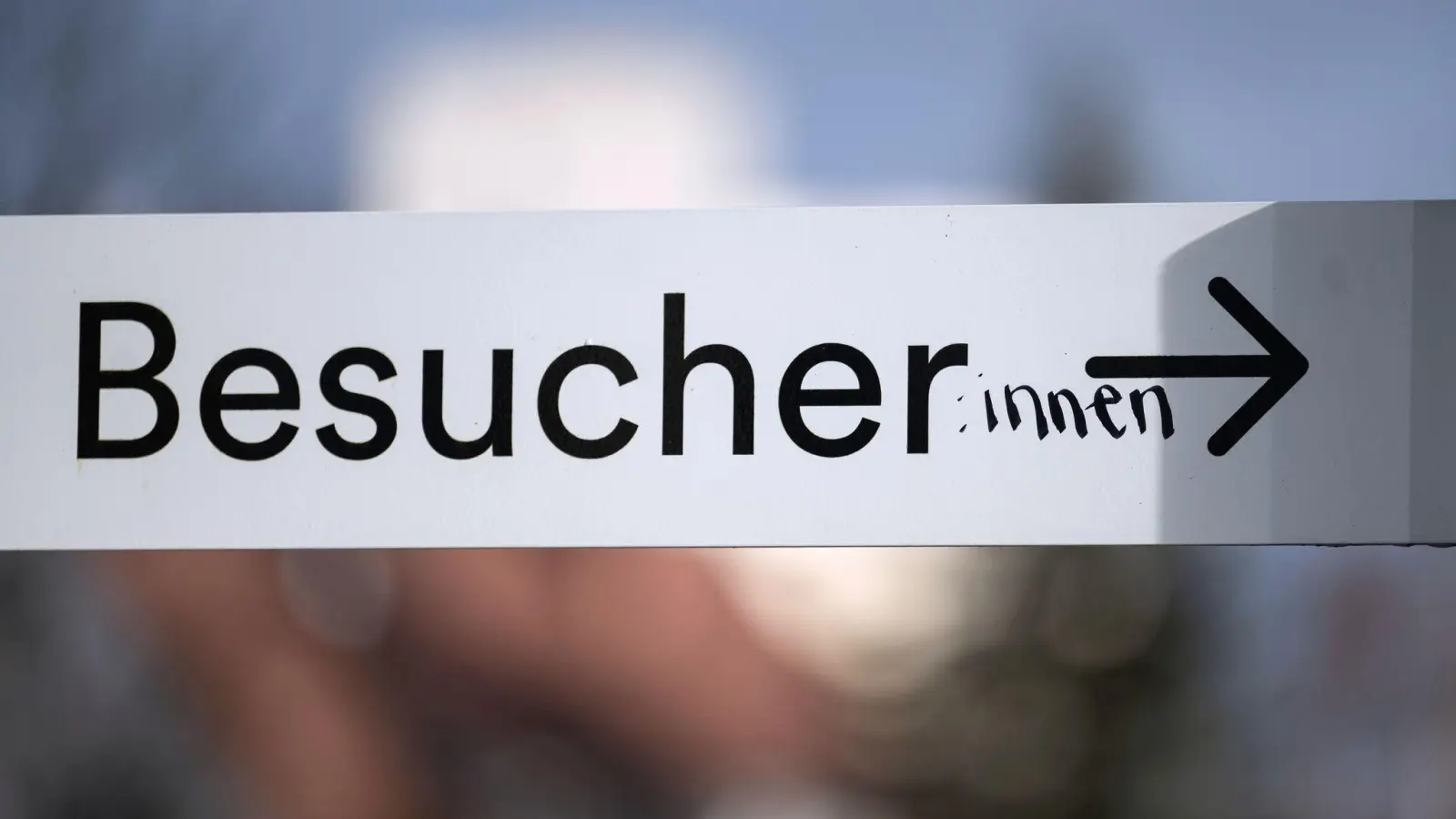 Das Wort „Besucher” ist auf einem Schild in der Innenstadt mit dem Zusatz „:innen” versehen. (Bild: Marijan Murat/dpa)