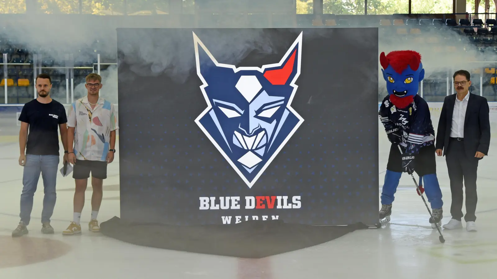 Nur der Nebel störte ein bisschen, sonst gab es positive Reaktionen auf das neue Logo der Blue Devils. Stefan Nörl, für Social Media zuständig, Stadionsprecher Marvin Domalewski, Maskottchen „Deiferl” und Franz Vodermeier, Geschäftsführer der Blue-Devils-Spielbetriebs-GmbH (von links), stellten das neue Wappen vor. (Bild: gb)