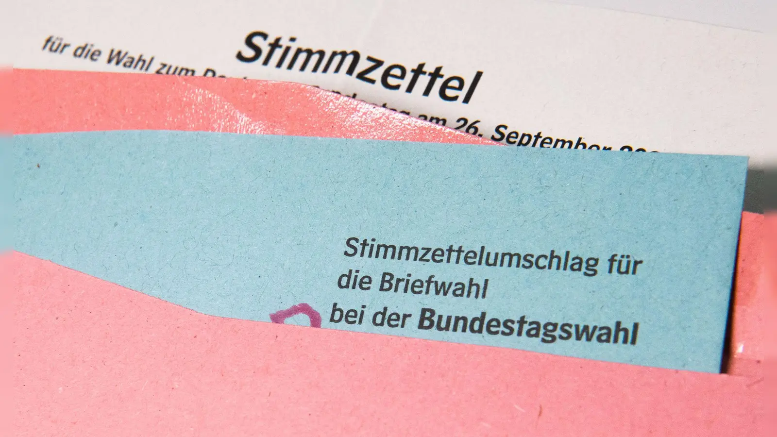 Ein Muster eines Stimmzettelumschlags für die Briefwahl bei der Bundestagswahl 2021 liegt auf einem Tisch. (Symbolbild: Julian Stratenschulte/dpa)