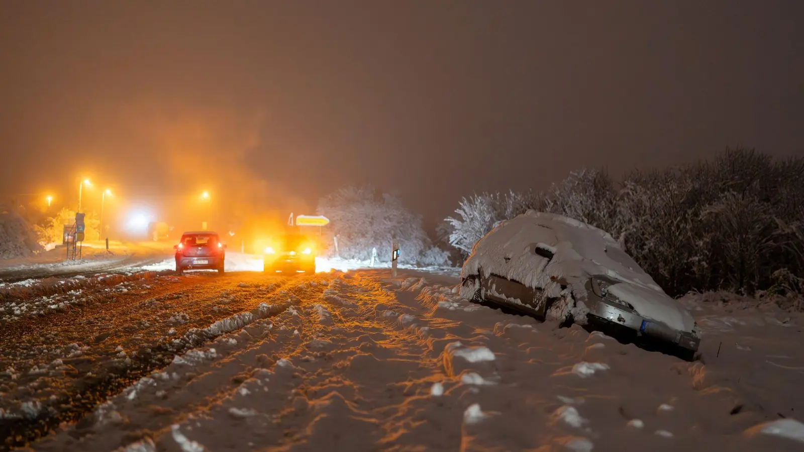 Nach starkem Schneefall liegt ein Auto in der Nähe von Wiesbaden im Graben. (Bild: 5VISION.NEWS/dpa)
