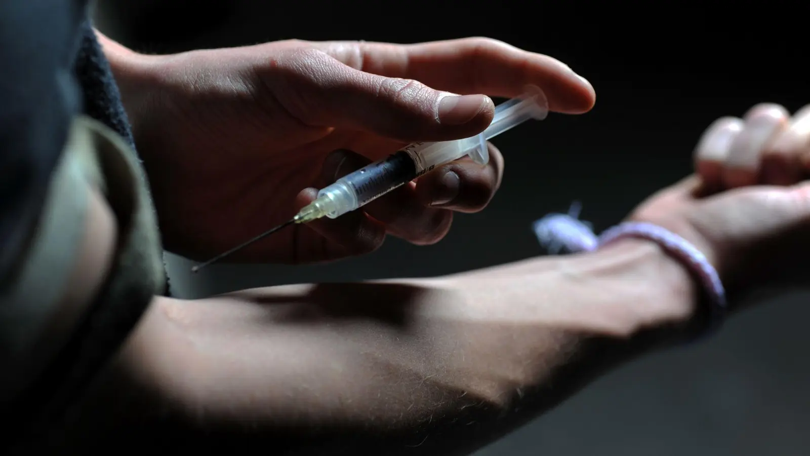 Ein Mann hält eine Heroinspritze an seinen Arm (Illustration). „Der Drogenkonsum wird in Europa schlimmer“, sagt EU-Innenkommissarin Ylva Johansson. (Bild: Frank Leonhardt/dpa)