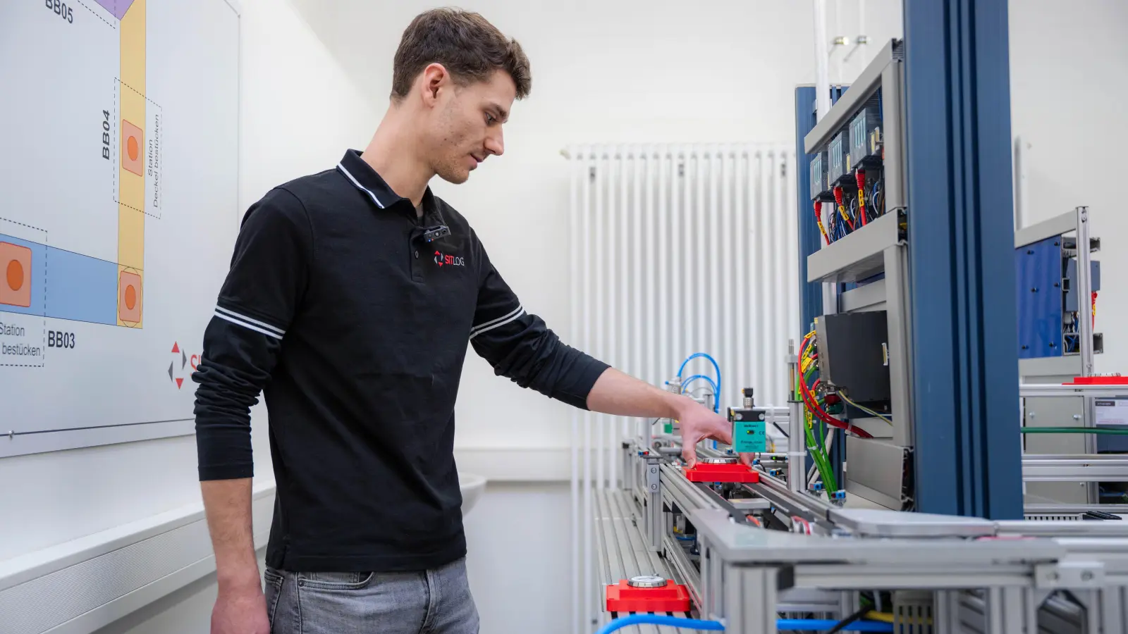 Fabian Walter ist bei Sitlog für die Auszubildenden zuständig und zeigt, wie die Lernfabrik funktioniert.  (Bild: Noah Wegmüller-Kocher)