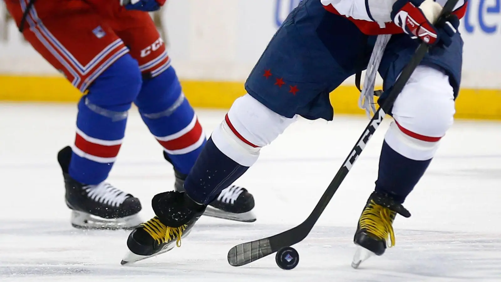 Zwei Eishockeyspieler kämpfen um den Puck. (Symbolbild: John Munson/AP/dpa)