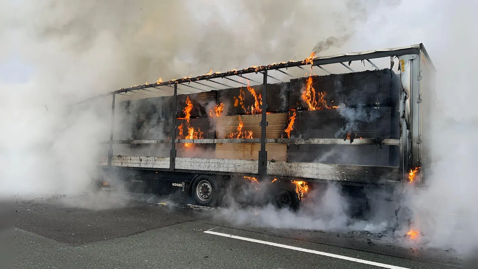 Ein mit Holz beladener Sattelzug brennt auf der Autobahn A72 bei Bayreuth. (Bild: -/Verkehrspolizei Hof/dpa)
