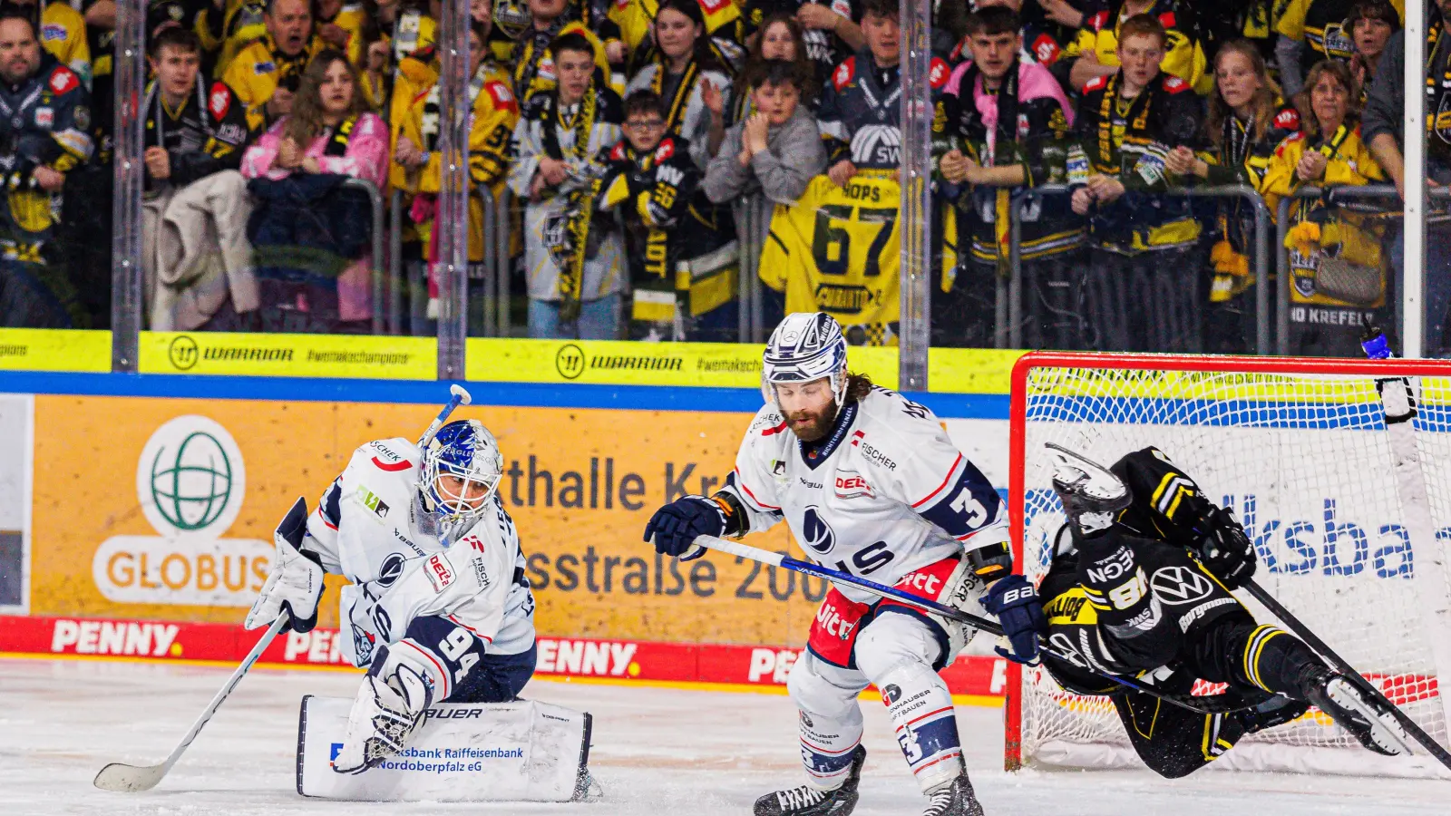 Der Weidener Verteidiger Tommy Muck (Mitte) lässt in dieser Szene den Krefelder Maximilian Adam (rechts) über den Schläger gleiten, Goalie Marco Wölfl wäre chancenlos gewesen. (Bild: Werner Moller)