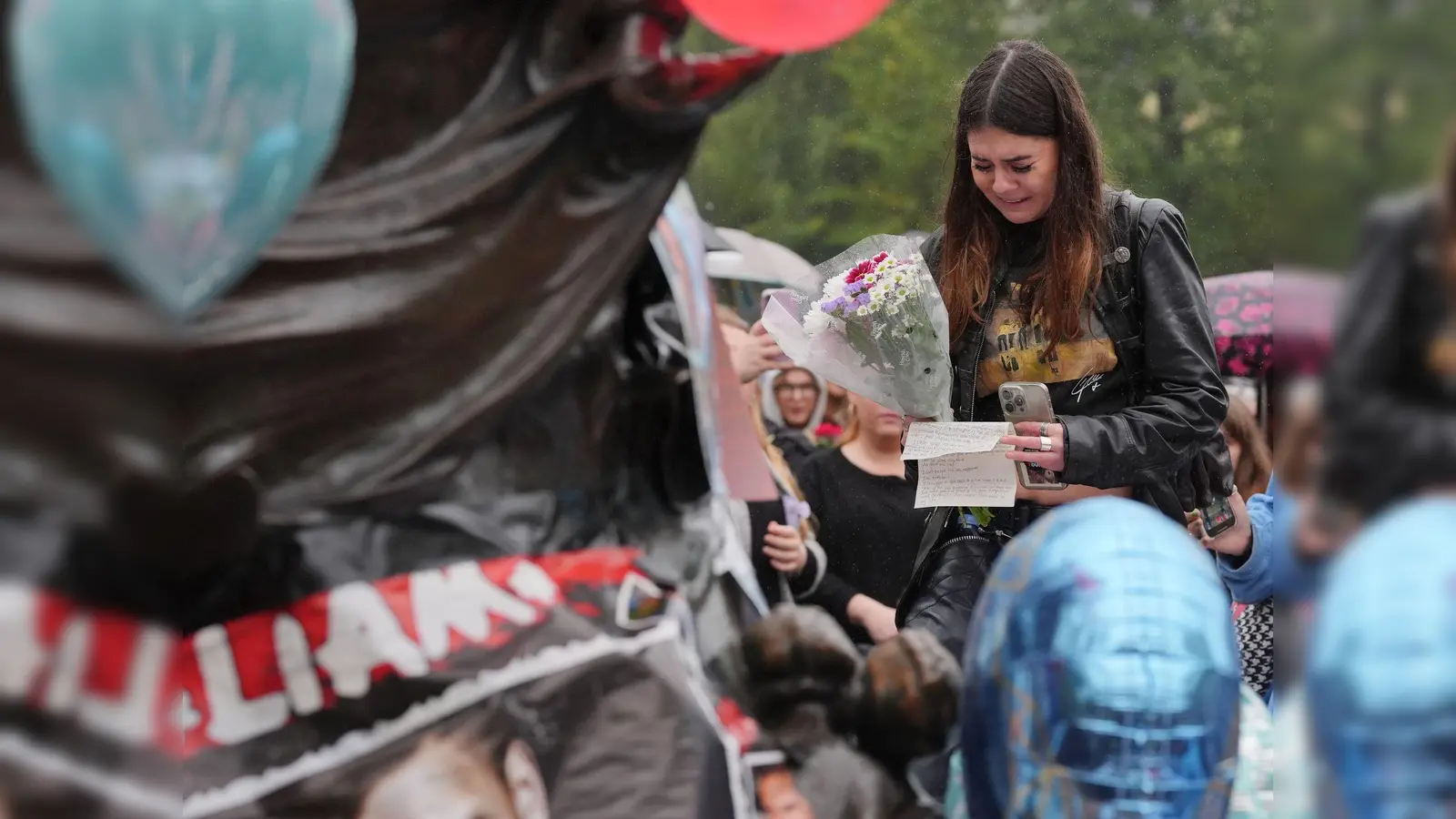 Fans legten Blumen und Briefe nieder und hielten Ballons. (Bild: Jonathan Brady/PA Wire/dpa)