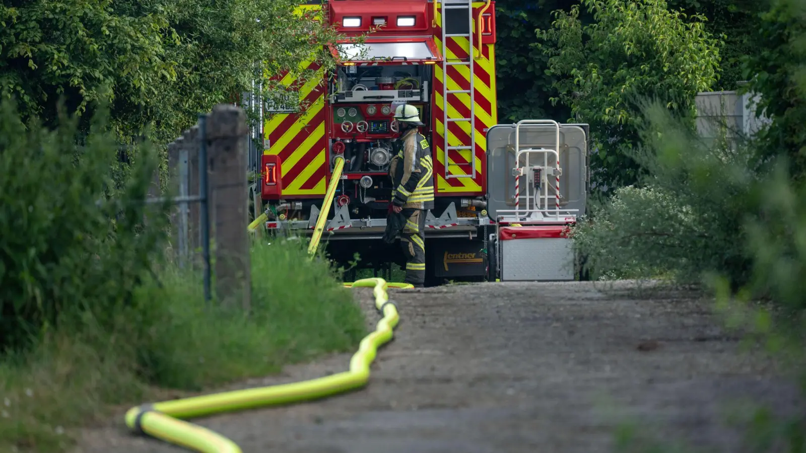 Die Feuerwehr konnte am Sonntagnachmittag erst löschen nachdem die Polizei das Gelände sicherte (Bild: Pia Bayer/dpa)