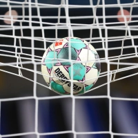 Ein Fußball liegt vor der Partie im Netz. (Bild: Friso Gentsch/dpa/Symbolbild)