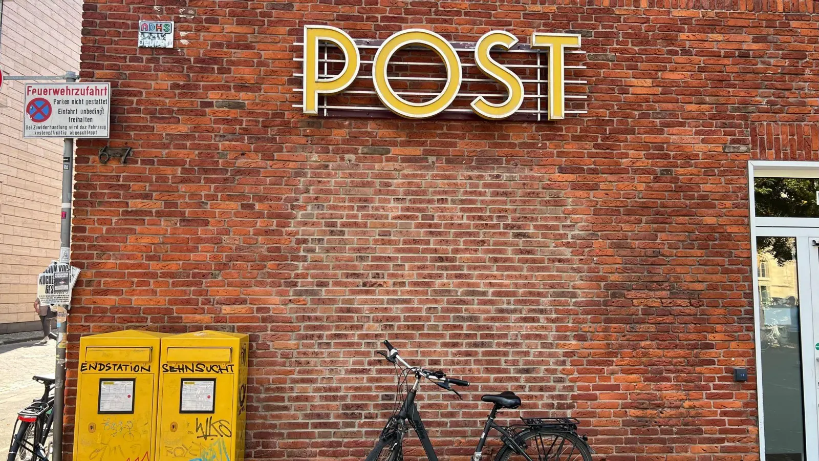 Ein Fahrrad steht vor einer Filiale der Postbank, die als Postfiliale fungiert. Anderswo in Deutschland gibt es keine Postfilialen, obwohl es sie einer staatlichen Vorschrift zufolge geben müsste. (Bild: Wolf von Dewitz/dpa)