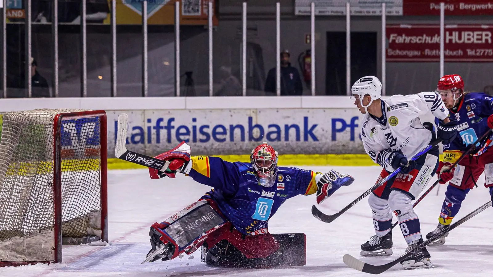 Der Weidener Vincent Schlenker (weißes Trikot) taucht vor dem Peitinger Goalie Andreas Magg auf. Die Blue Devils gewannen am Freitag auch das vierte Viertelfinal-Match gegen den EC Peiting und stehen damit im Play-off-Halbfinale. (Bild: Werner Moller)