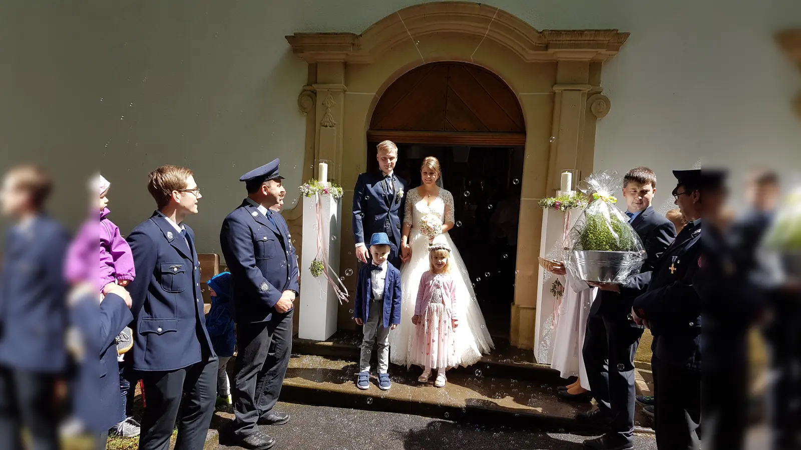 Die Brautleute am Kirchenportal mit Spalier der Feuerwehr Heinersreuth. (Bild: hzi)