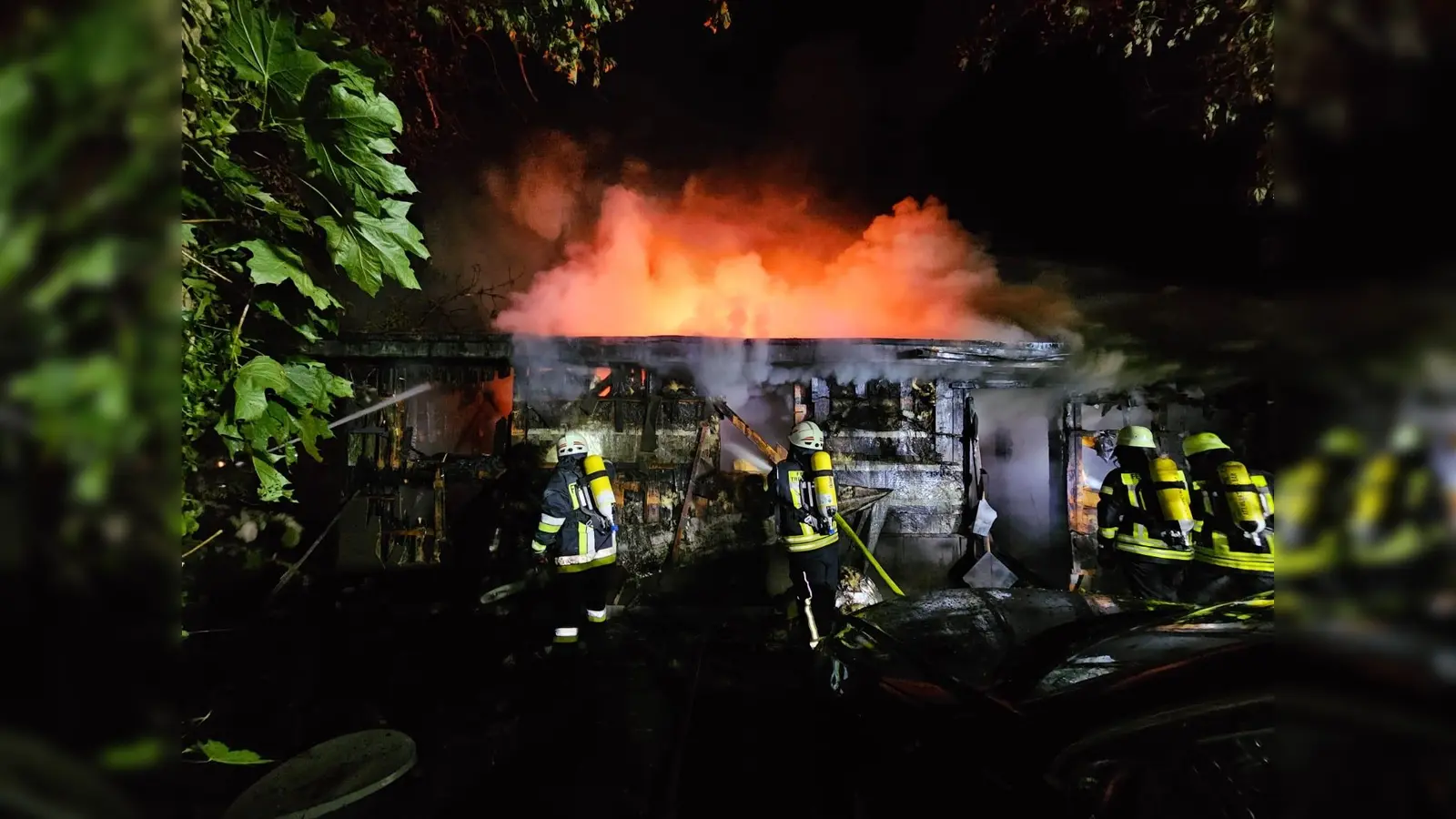 Feuerwehrleute löschen das brennende Bootshaus am Rußweiher.  (Bild: Feuerwehr Eschenbach )