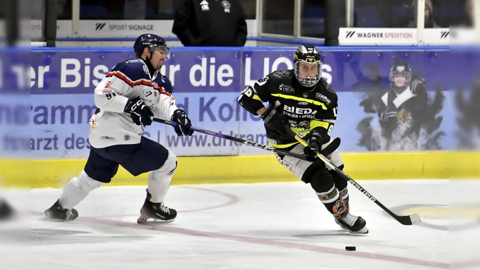 Trotz heftiger Gegenwehr seines Gegenspielers von den Schönheider Wölfen kann sich in dieser Szene Marco Pronath (rechts) vom ERSC Amberg an der Scheibe behaupten.  (Bild: Hubert Ziegler)