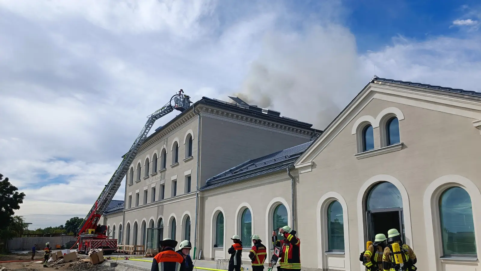 Von der Drehleiter aus soll der Brand auf dem Wiesauer Bahnhofsgebäude bekämpft werden. (Bild: nic)