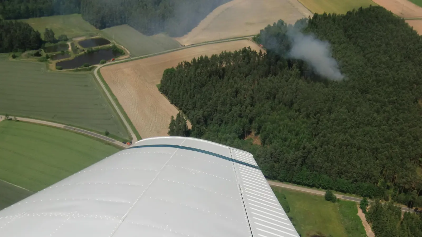 So sieht das von oben her aus, wenn die Luftbeobachter ihre Kreise ziehen: Rauch dringt aus einem Waldstück, das Feuer greift rasch um sich. Eile ist geboten. Auch vom 14. bis 18. August sind über der Oberpfalz wieder Luftbeobachter unterwegs, da die Waldbrandgefahr hoch ist.  (Symbolbild: Wolfgang Houschka)
