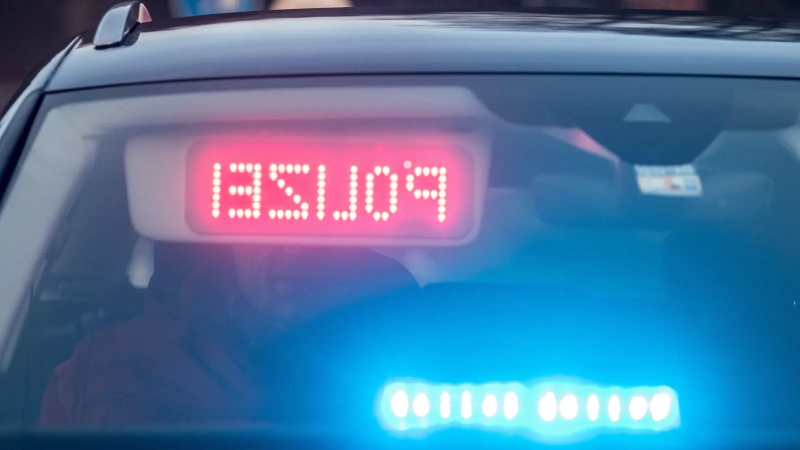 Ein Warndisplay mit der Spiegelschrift „Polizei” ist in einem Zivilfahrzeug der Polizei angebracht. Die Verkehrspolizei stellte bei einer Lkw-Kontrolle etliche Gesetzesverstöße fest. (Symbolbild: Armin Weigel/dpa)