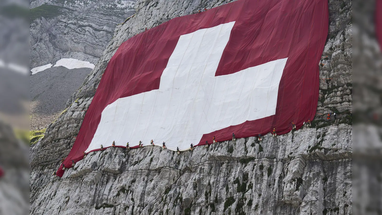 Anfang August wird am Säntis eine riesige Schweizerfahne zum Nationalfeiertag angebracht und danach wieder abgebaut. Höhenarbeiter beteiligten sich am Rettungseinsatz. (Bild: Gian Ehrenzeller/KEYSTONE/dpa)