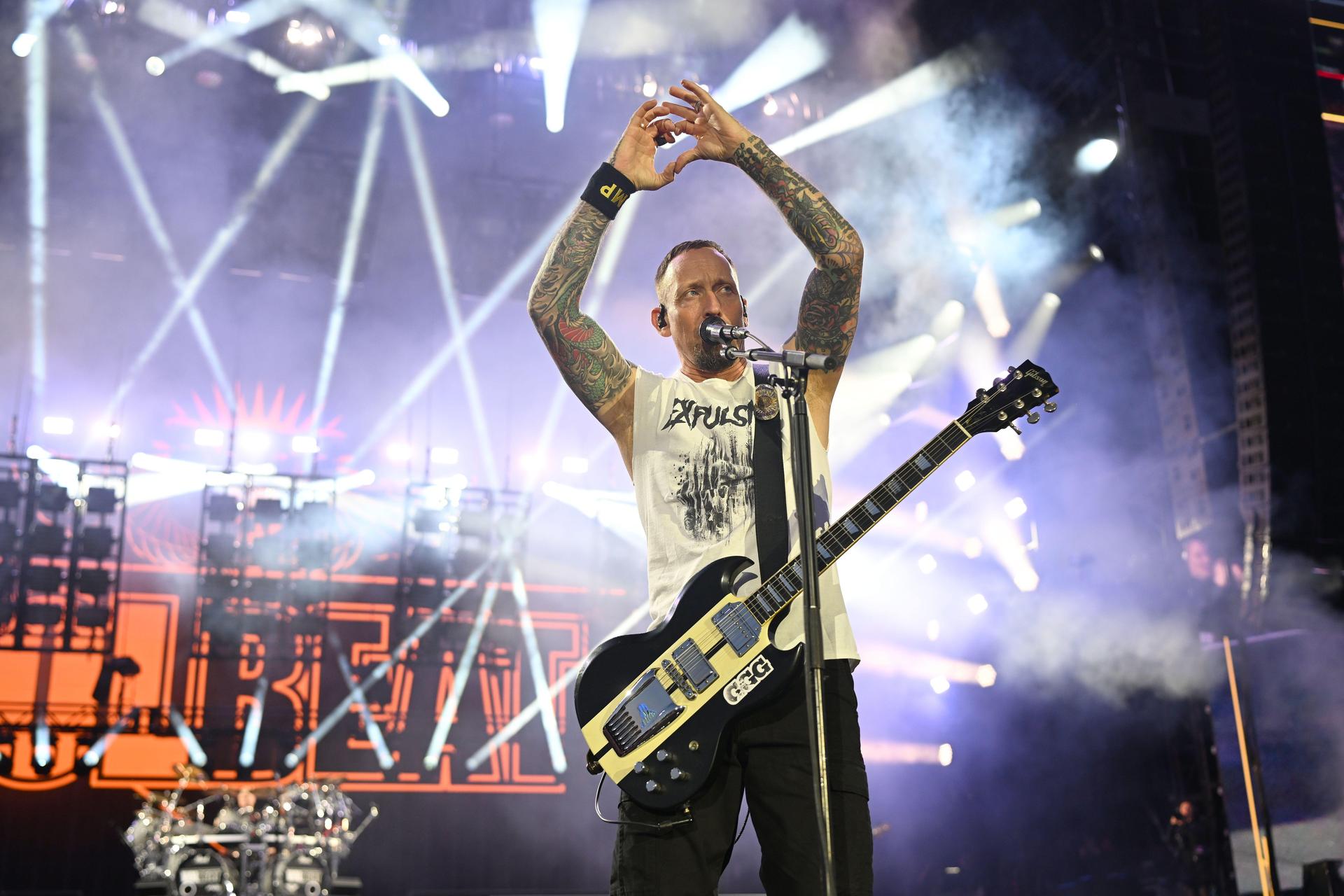 Volbeats Michael Poulsen mit der symbolträchtigen Geste zu einem friedvollen und harmonischen Festival. (Bild: Tobias Schwarzmeier)