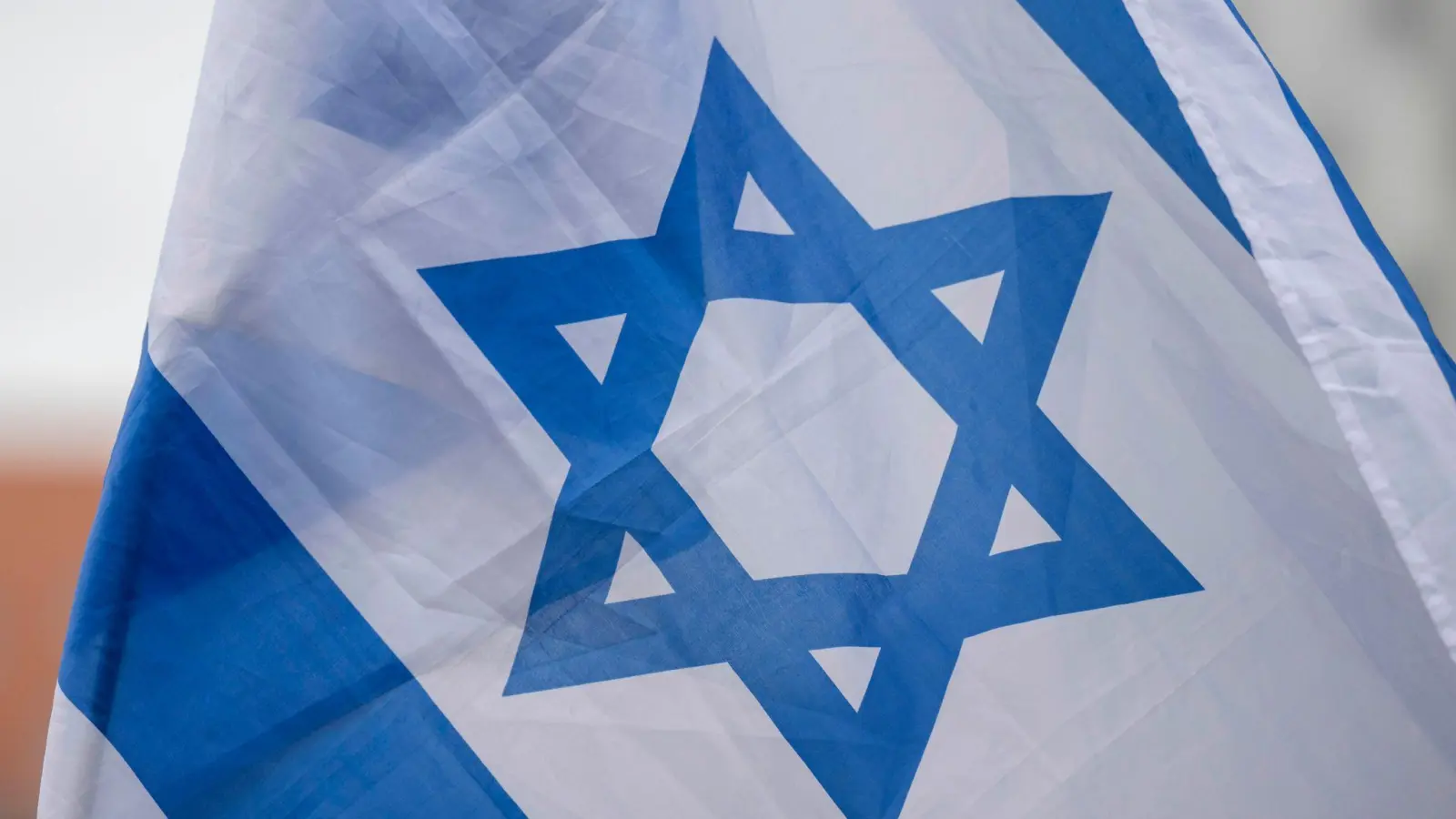 Eine Flagge von Israel weht auf einer Solidaritätskundgebung nach dem Großangriff von Hamas auf Israel. (Symbolbild: Hendrik Schmidt/dpa)