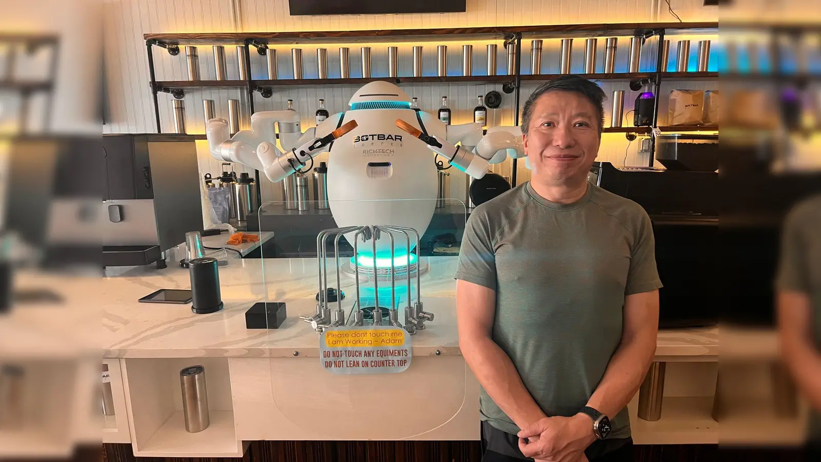 Sunny Lam und sein Barista Adam - der erste Roboter-Kaffeemacher in der US-Ostküstenmetropole New York. (Bild: Benno Schwinghammer/dpa)