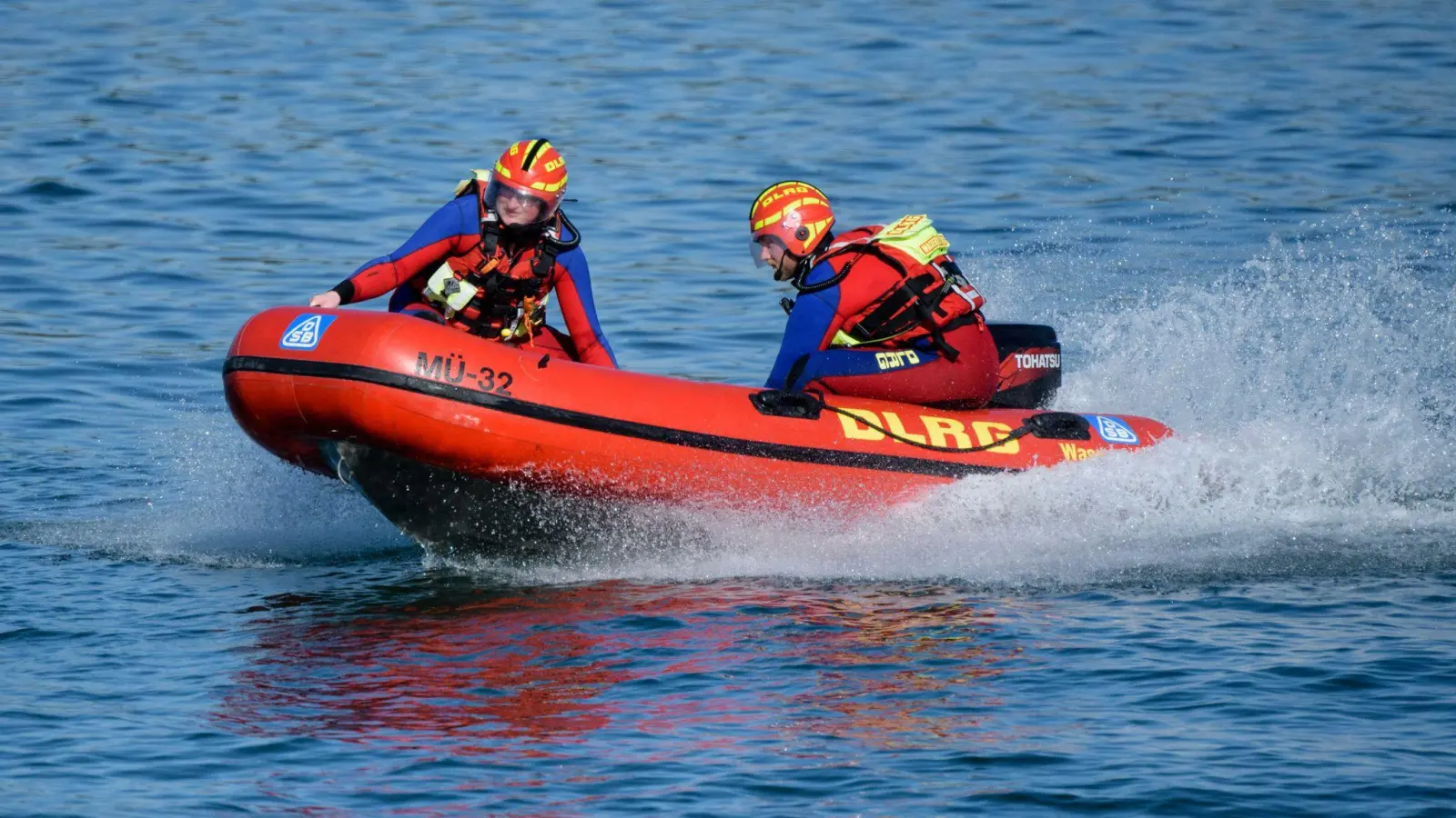 Wasserretter der Deutschen Lebens-Rettungs-Gesellschaft (DLRG) fahren in einem Schnellboot über den Chiemsee. (Bild: Matthias Balk/dpa/Archivbild)