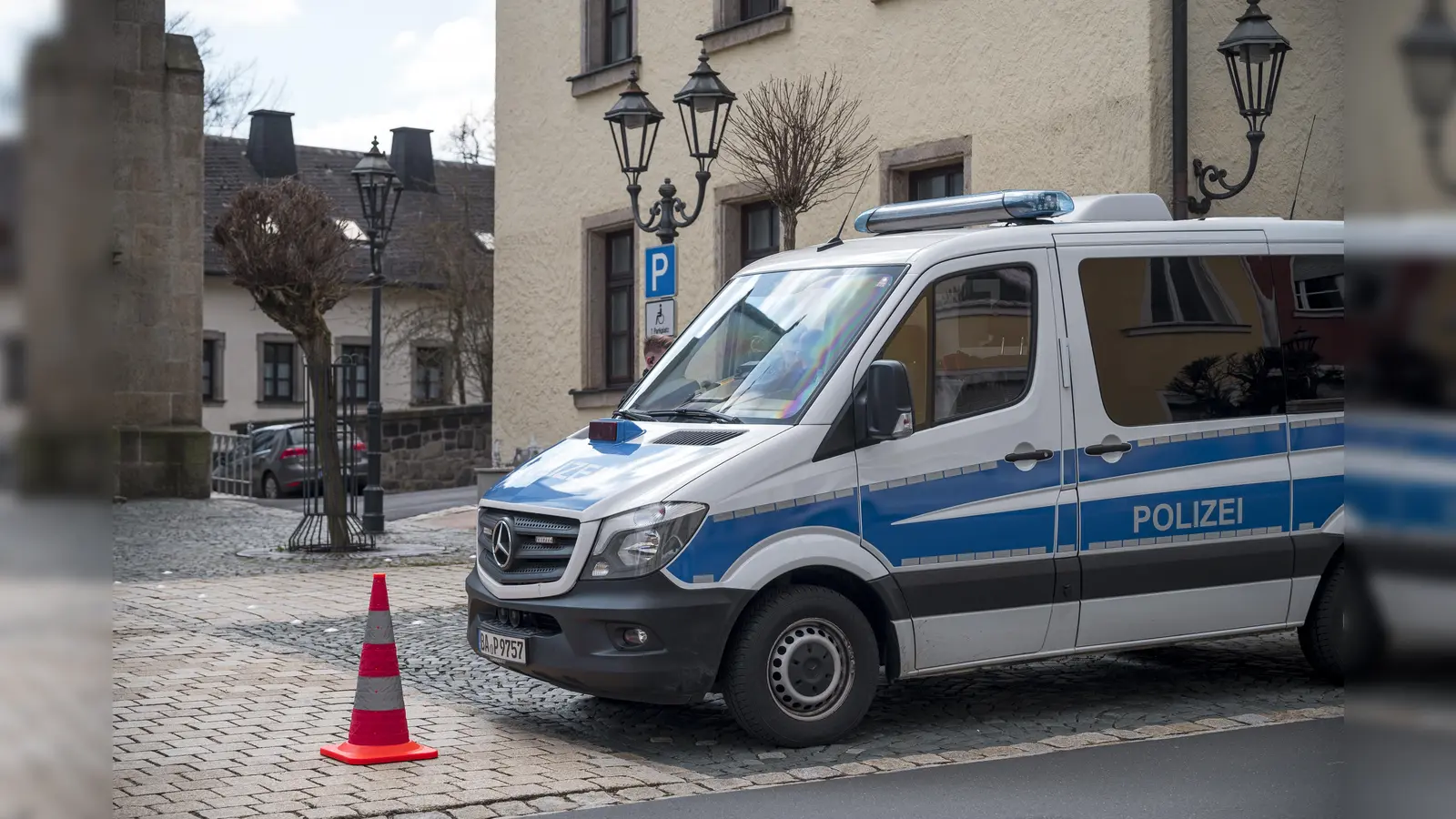 Ein Einsatzwagen der Polizei sperrt die Straße zu einem Kinder- und Jugendhilfezentrum ab. In der Einrichtung war am Vortag eine Zehnjährige tot in einem Zimmer gefunden worden. (Bild: Daniel Vogl/dpa)