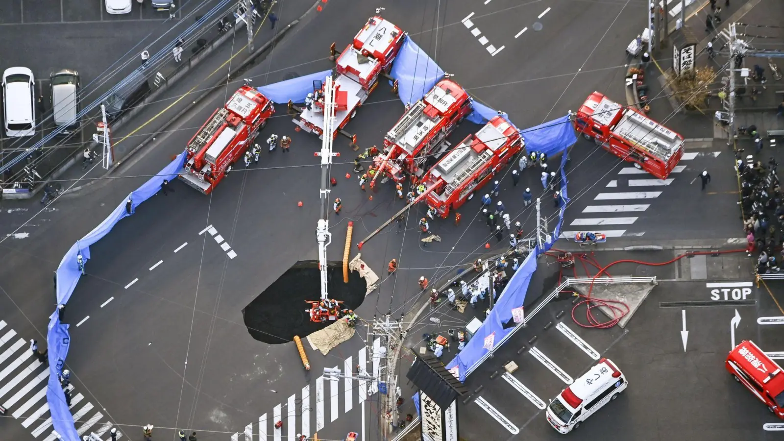 Mitten auf einer Kreuzung brach in Japan die Straße ein. (Bild: -/kyodo/dpa)