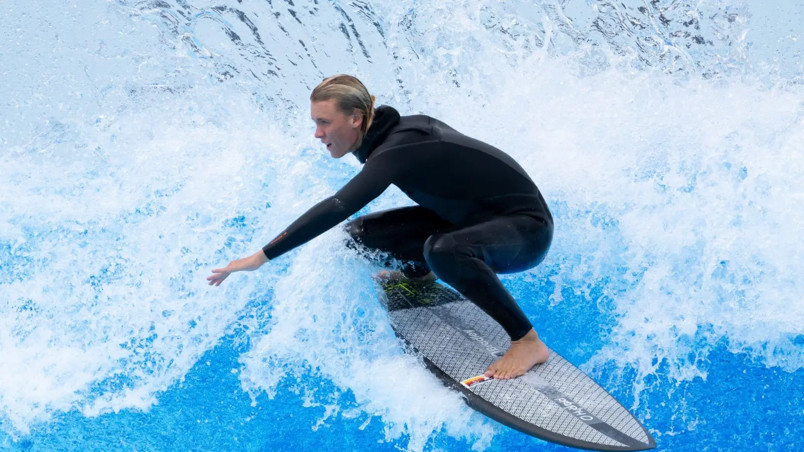 Tim Elter, Surfer, surft vor der Eröffnung von Deutschlands erstem Surfpark während einer Pressekonferenz auf der Anlage der O2 Surftown. (Bild: Sven Hoppe/dpa)