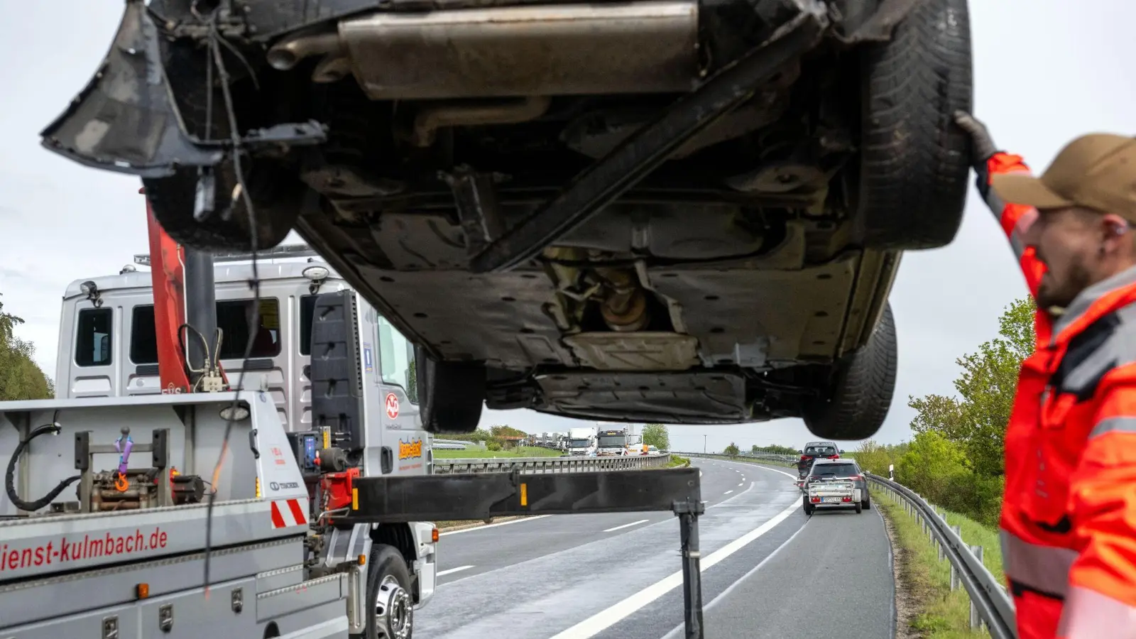 Ein Auto wird von einem Abschleppwagen in die Höhe gehoben, auf der Gegenfahrbahn herrscht noch langer Stau. (Bild: Pia Bayer/dpa)