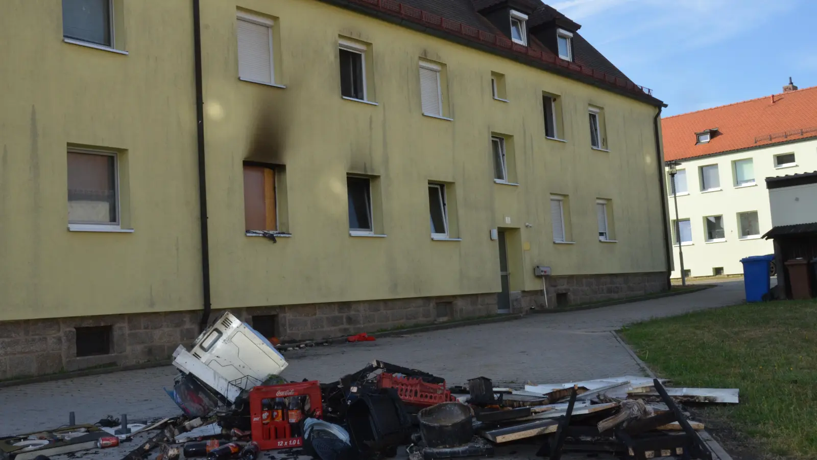 Am Morgen danach deuten die rußgeschwärzte Außenwand und zerstörtes Interieur auf den nächtlichen Brand in dem Mehrfamilienhaus hin. (Bild: Elisabeth Dobmayer)