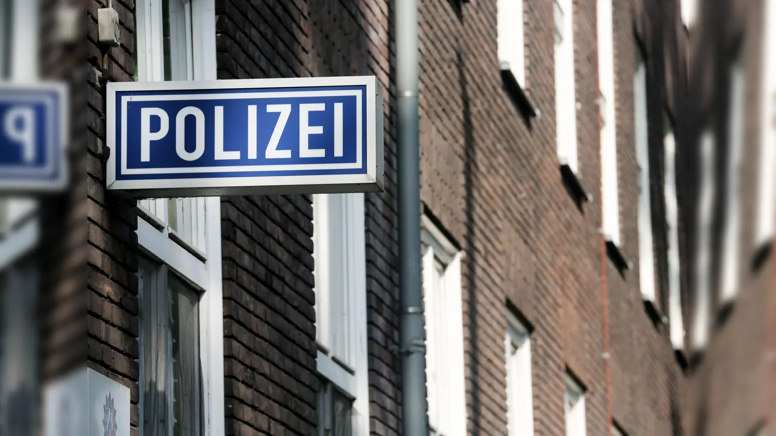 Ein Schild mit der Aufschrift „Polizei“ hängt an einem Polizeipräsidium. (Bild: Roland Weihrauch/dpa/Symbolbild)