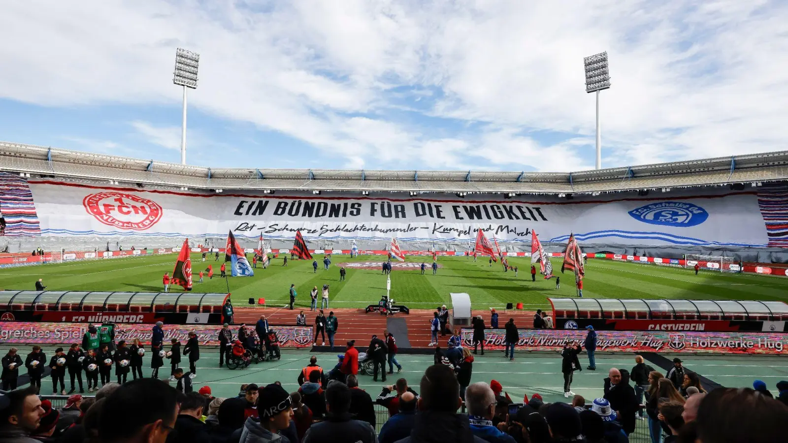 Die Fans vom 1.FC Nürnberg und von Schalke 04 zeigen eine gemeinsame Choreo über die gesamte Stadionhälfte. (Bild: Daniel Löb/dpa)