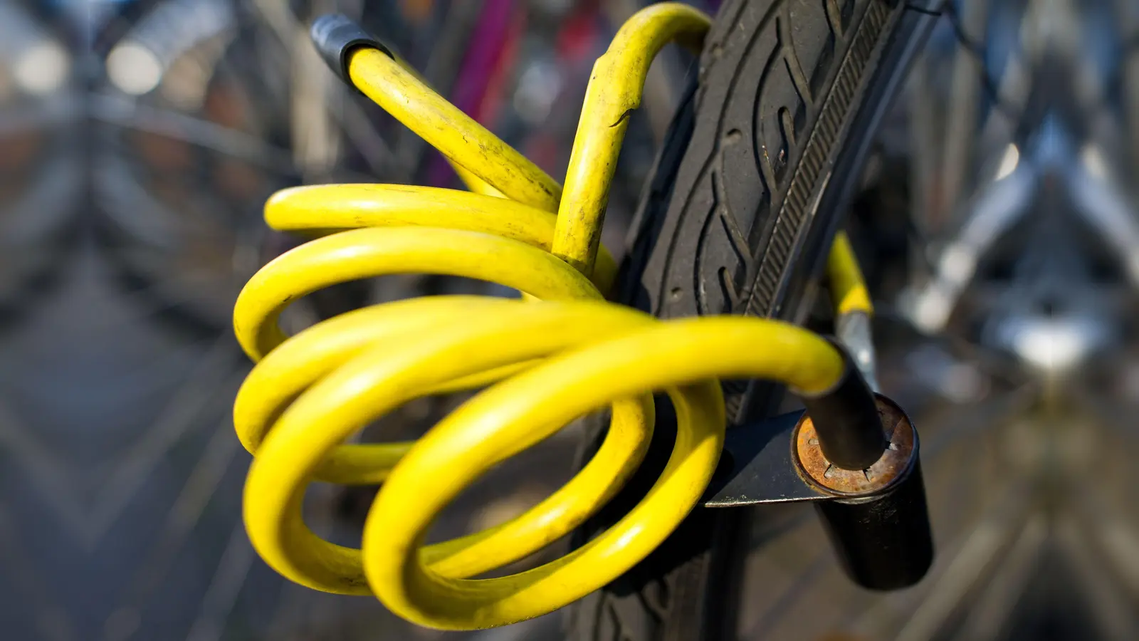 Ein Fahrradschloss hängt an einem Fahrradreifen. In Weiden hat jemand ein abgesperrtes Rad in der Altstadt gestohlen.  (Symbolbild: Uwe Anspach/dpa)