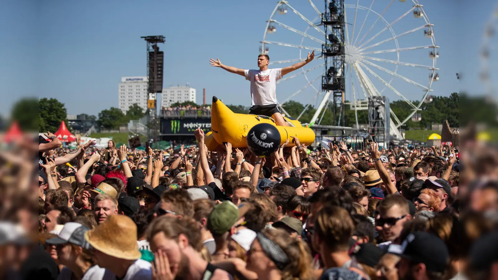 Ein Besucher des Open-Air-Festivals „Rock im Park” wird von anderen Besuchern während einem Konzert auf einer aufblasbaren Banane über die Menschenmenge getragen. (Archivbild: Daniel Karmann)