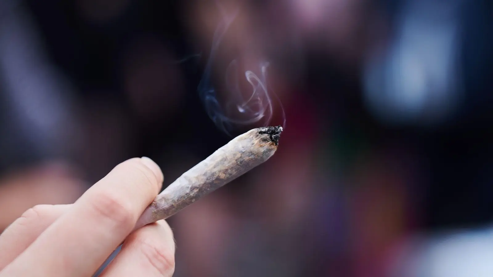 Eine Frau hält einen Joint in der Hand: Cannabis wird von der Liste der verbotenen Substanzen gestrichen. (Bild: Annette Riedl/dpa)