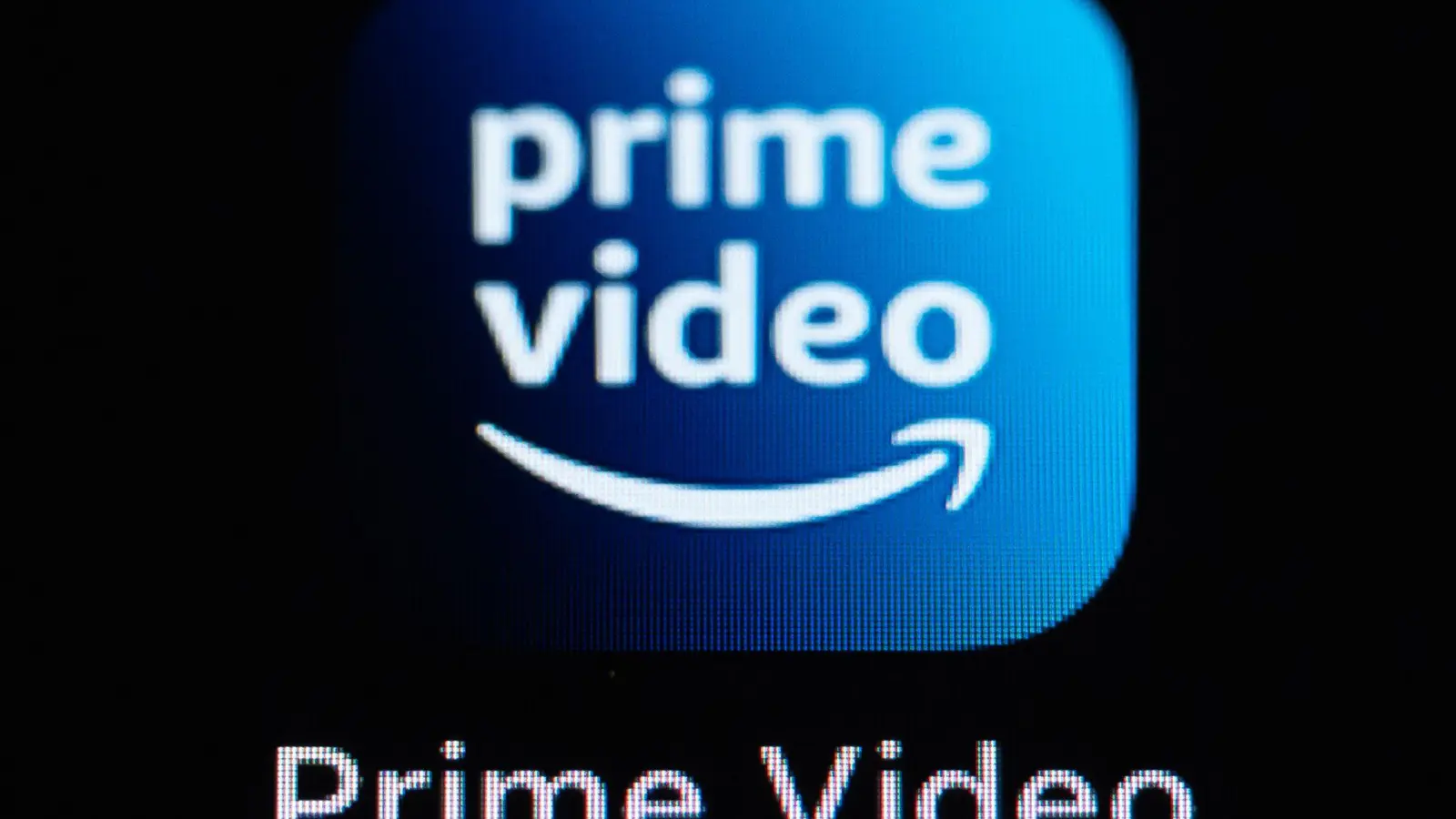 Die Amazon Prime Video-Anwendung auf dem Display eines iPhone SE zu sehen. Die Verbraucherzentrale NRW hat eine Sammelklage gegen das Unternehmen angekündigt. (Illustration) (Bild: Silas Stein/dpa)