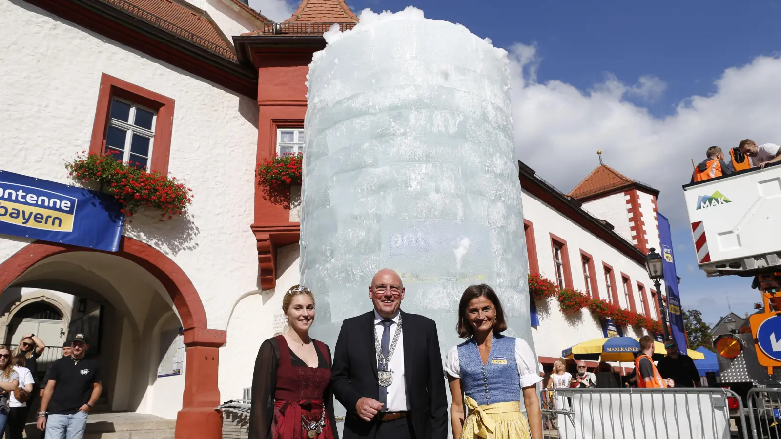 Ein großer Masskrug aus Eis steht in Marktredwitz. Über den Rekord freuen sich mit Bürgermeister Oliver Weigel, Bierkönigin Linnea Klee (links) und Marion Schieder, die „Heimatministerin” von Antenne Bayern (rechts).  (Bild: Antenne Bayern)