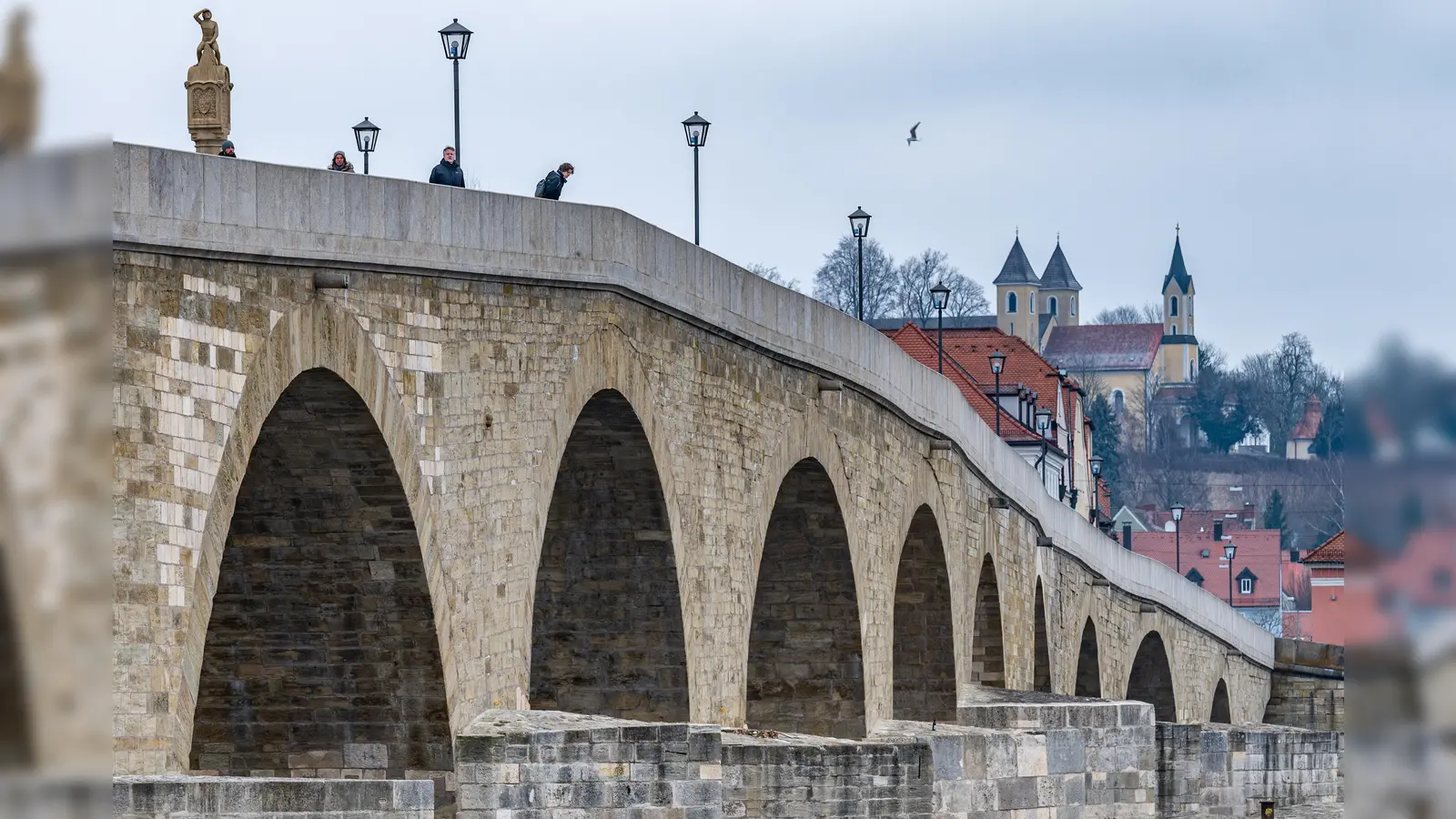 Die Steinerne Brücke in der Regensburger Altstadt. Das Opfer fiel auf den gepflasterten Bereich an einem Brückenpfeiler und wurde schwer verletzt. (Archivbild: Armin Weigel/dpa)