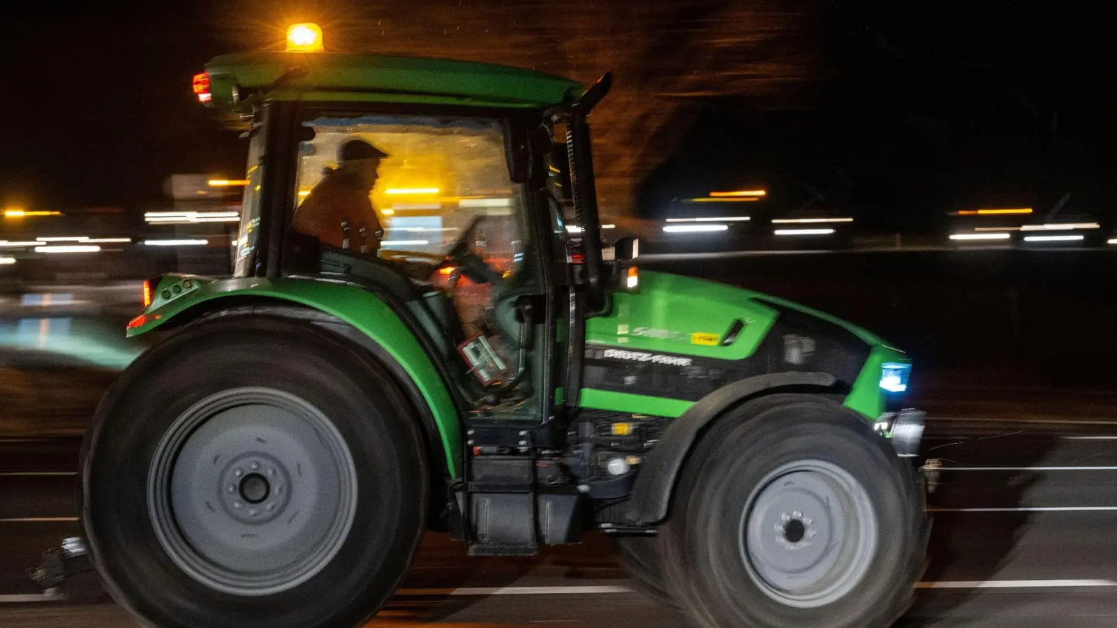 Ein Traktor fährt inmitten einer Kolonne. (Bild: Pia Bayer/dpa)