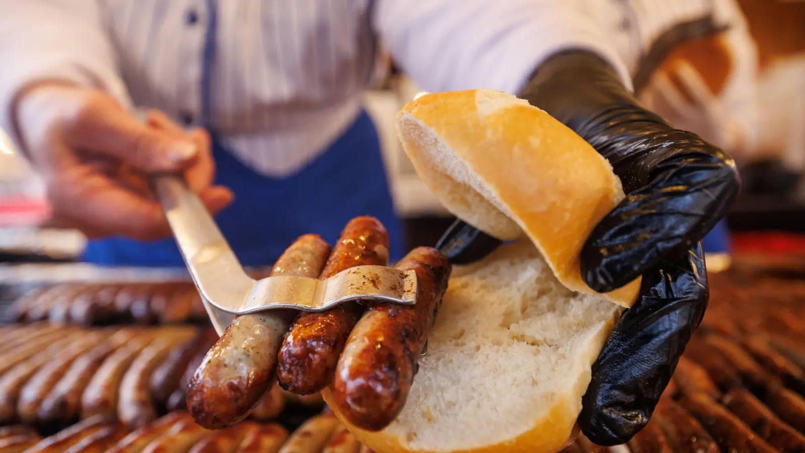 Nürnberger Rostbratwürste liegen in einem Brötchen. (Bild: Daniel Karmann/dpa/Archiv)