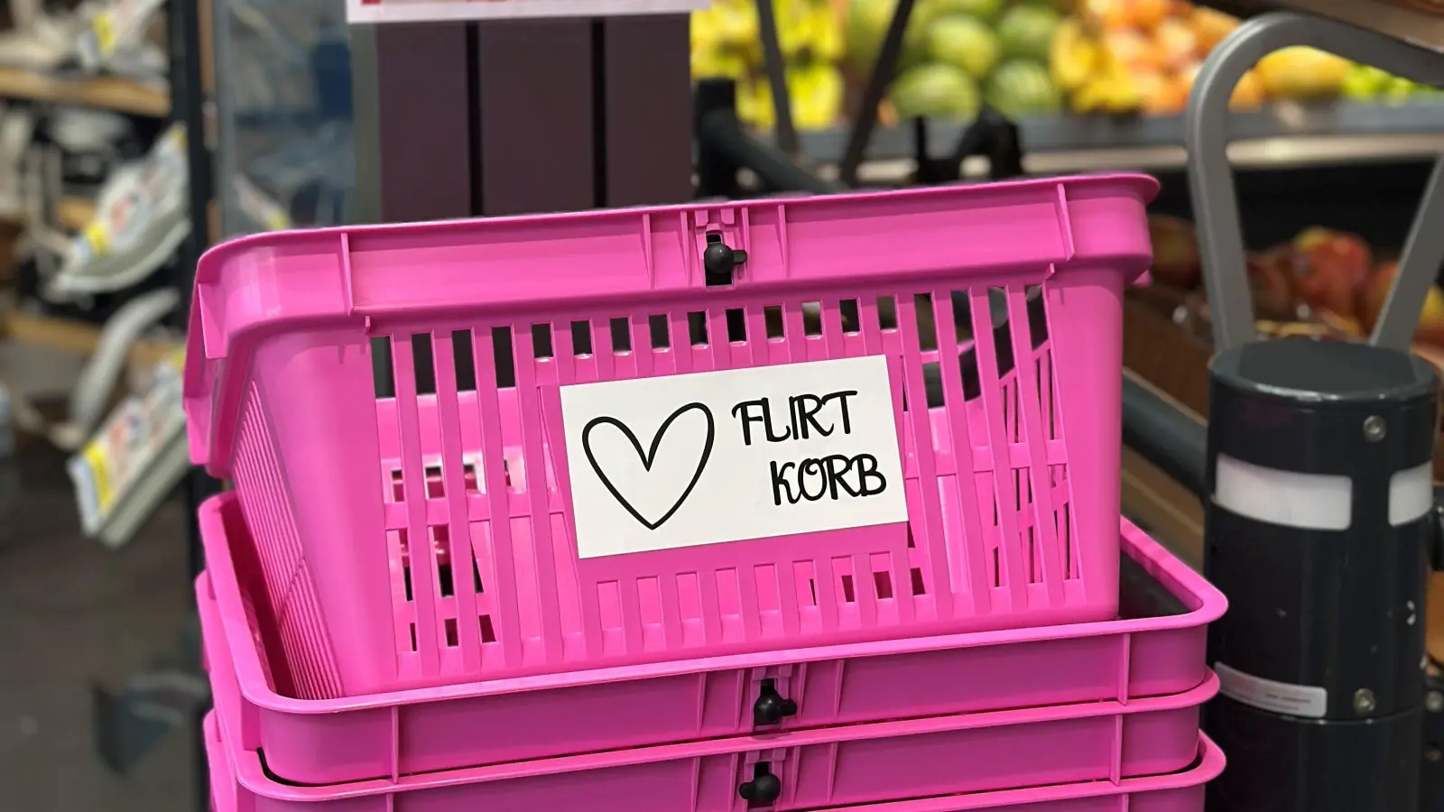 Mit einem Schild wird auf den Sinn der Flirtkörbe aufmerksam gemacht. Wer sich einen pinken Korb nimmt, signalisiert damit „offen für Begegnungen” zu sein.  (Bild: Raphael Dirnberger)