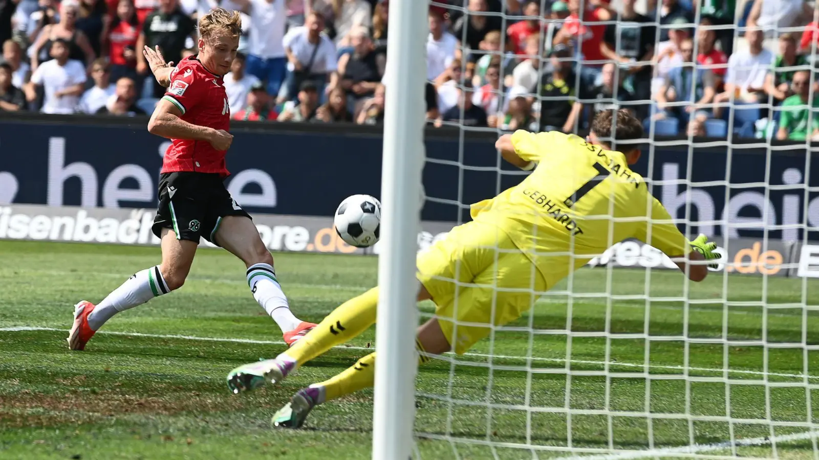 Jannik Dehm (l) erzielt das 2:0 für Hannover 96 gegen Jahn-Torwart Felix Gebhardt. (Bild: Swen Pförtner/dpa)